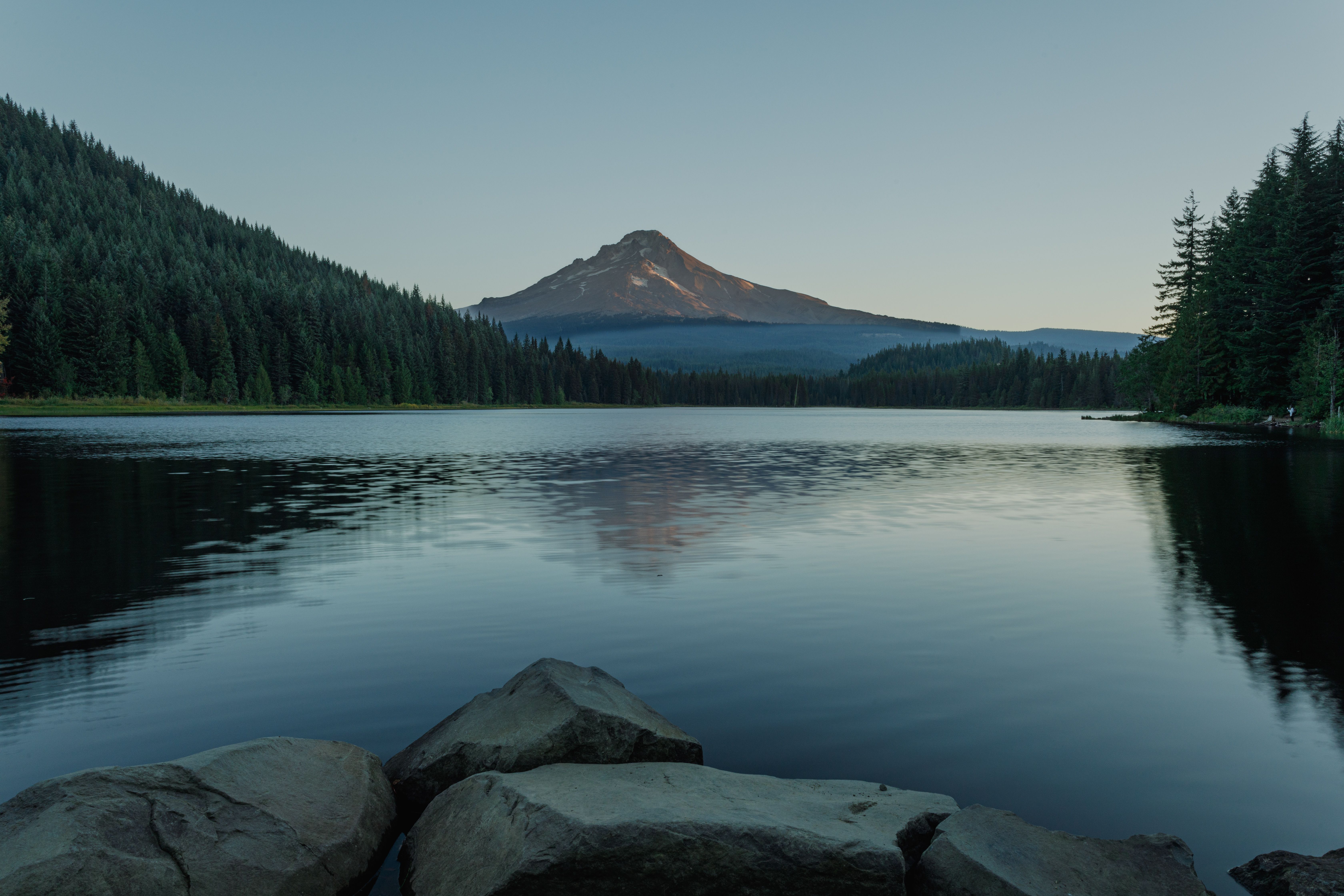 Snow-capped Mount Hood reflected in a still alpine lake surrounded by autumn-colored forest in the Oregon Cascades