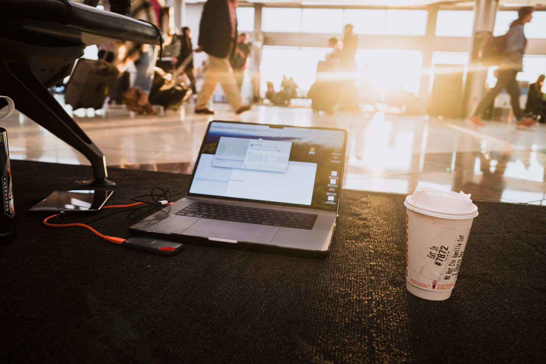 Passenger using laptop in bright airport terminal
