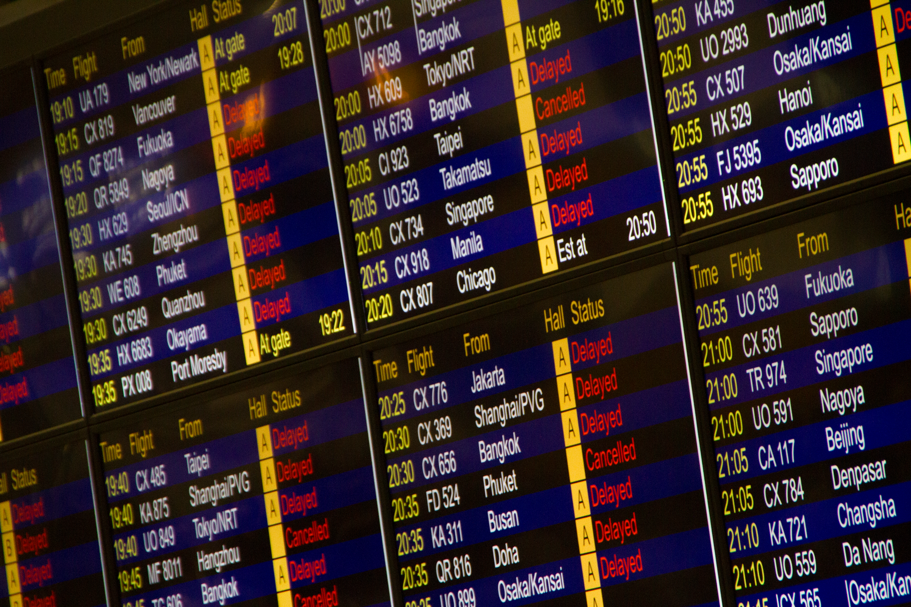 Traveler taking photo of airport departure board with smartphone