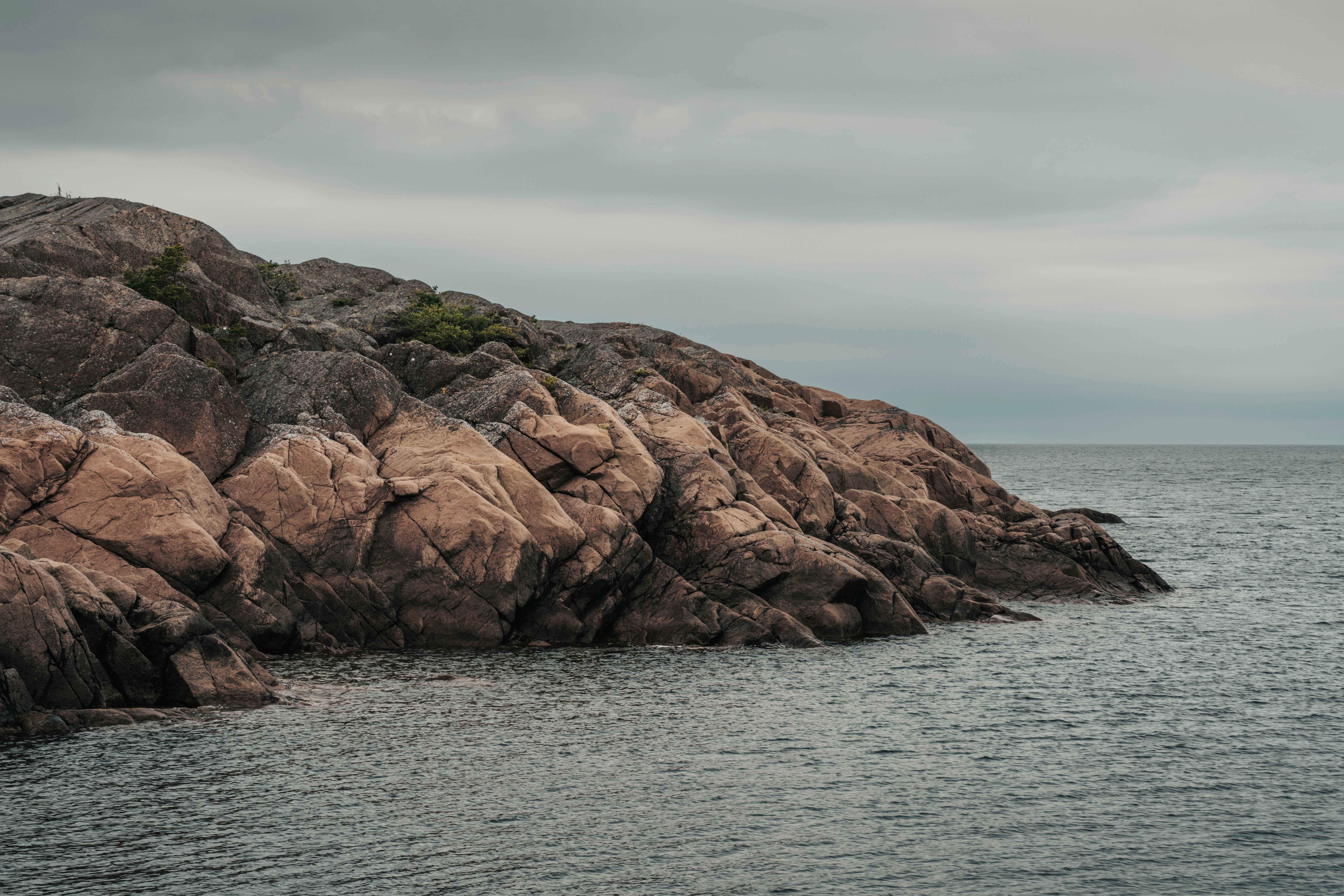 Rocky coastal trail along the dramatic clifftops of Monhegan Island, Maine, with Atlantic Ocean visible below under a wide open sky