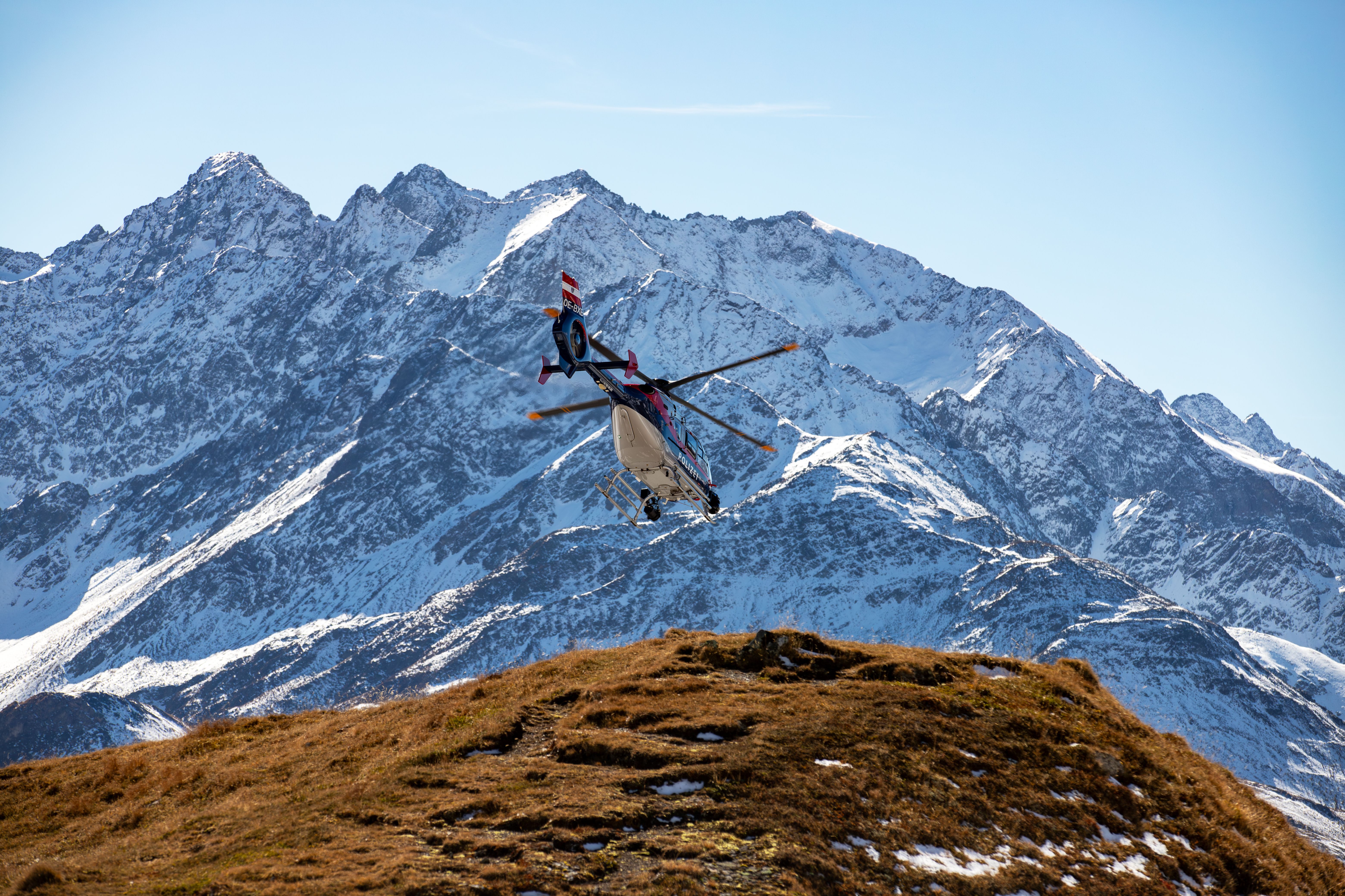 Medical evacuation helicopter airlifting a patient from a remote mountain location