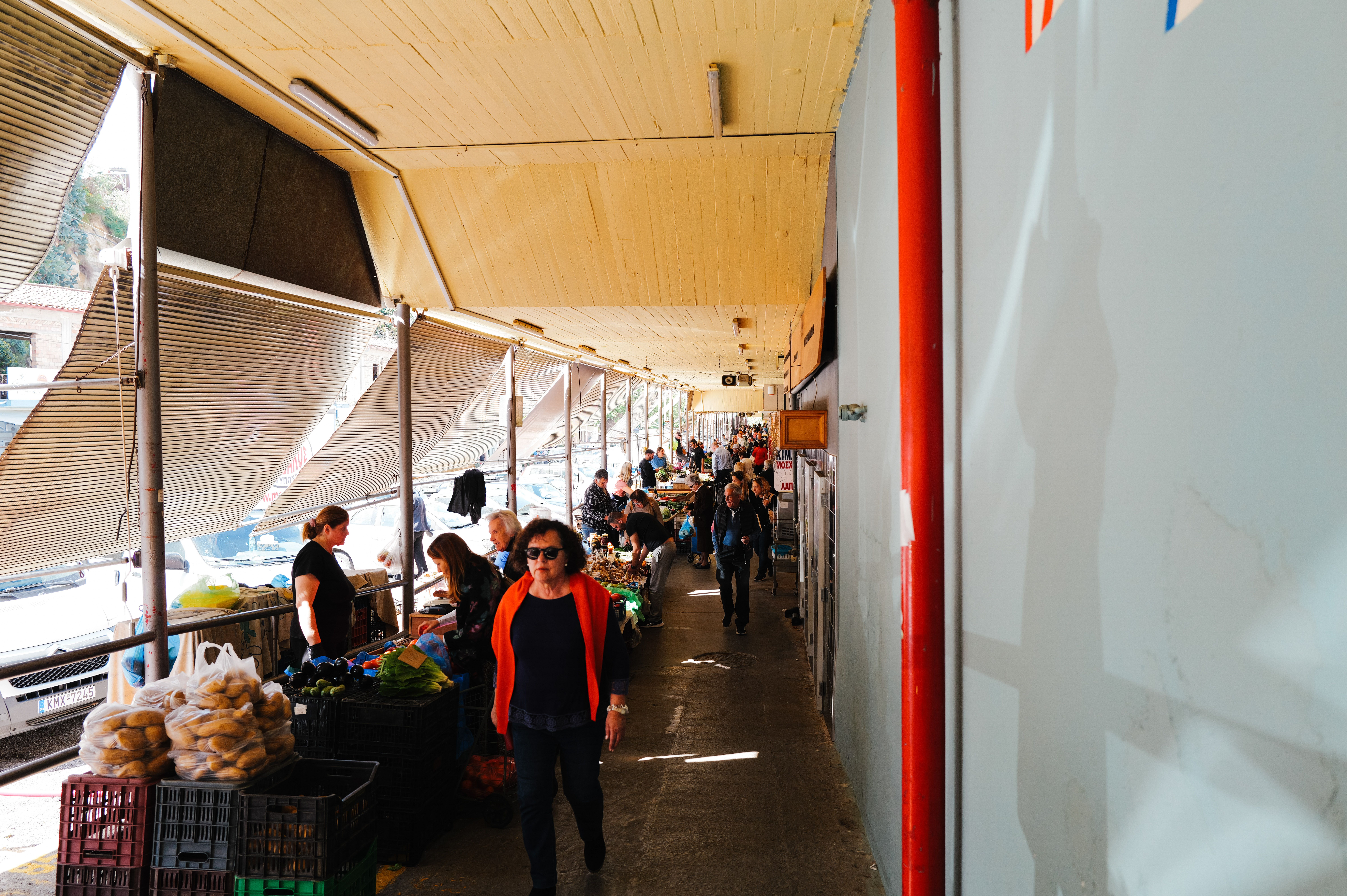 The interior of Mercato di Mezzo in Bologna, a vaulted historic covered market with food stalls selling fresh pasta, cheese, and charcuterie under warm overhead lighting