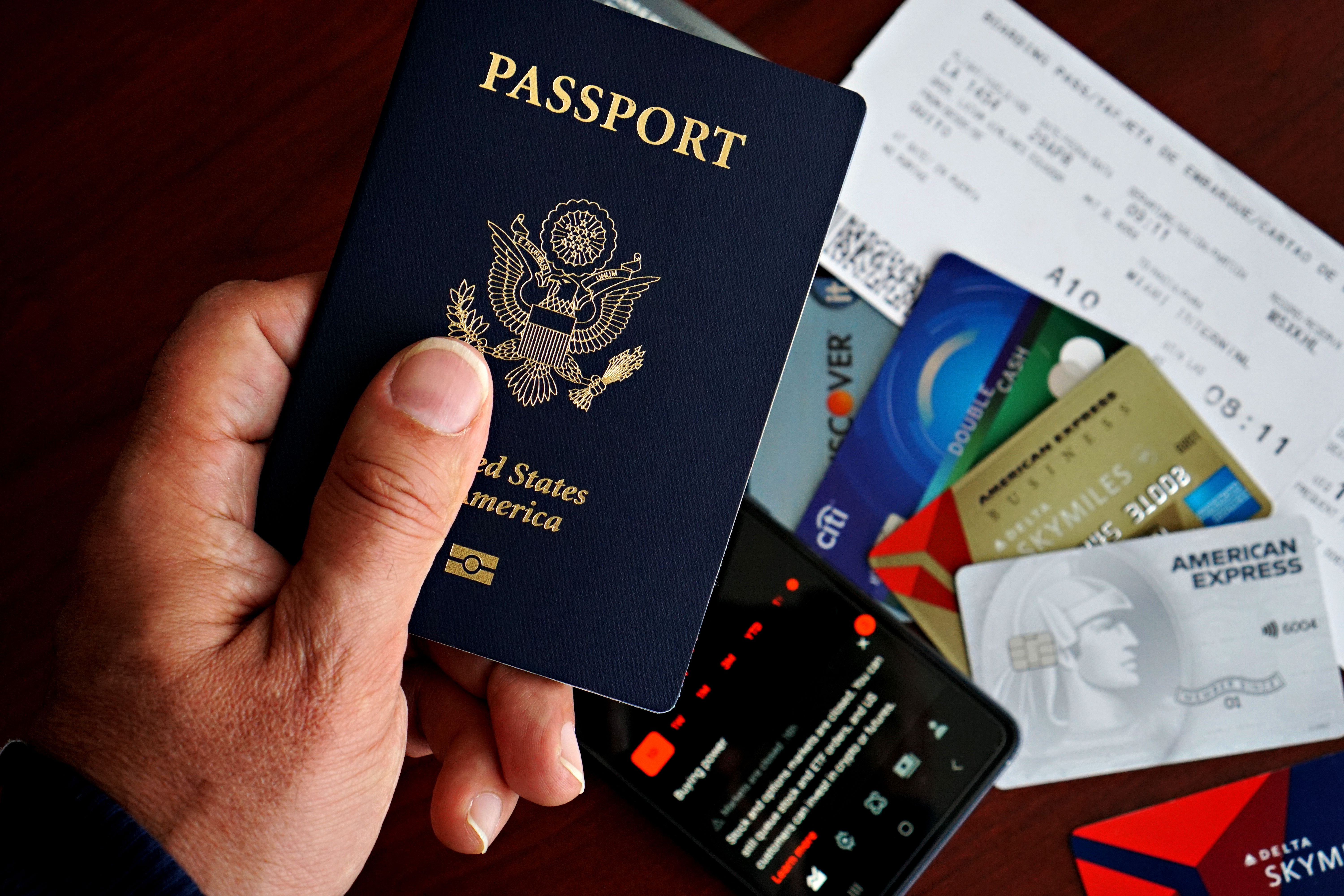 Premium travel rewards credit card resting on an open passport with foreign currency and a boarding pass
