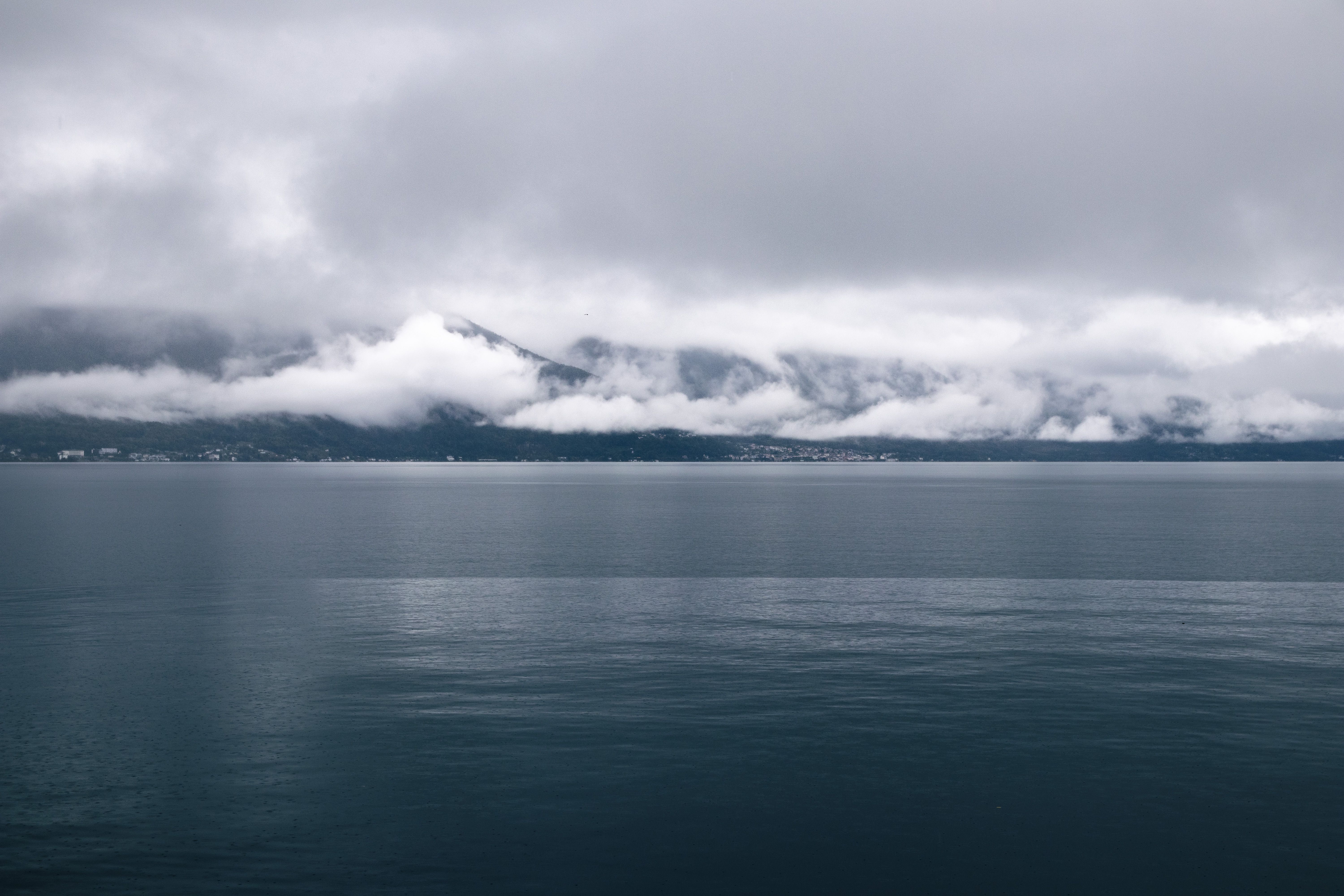 Clinique La Prairie medical wellness resort on the shores of Lake Geneva in Montreux, Switzerland, with snow-capped Alps reflected in the water