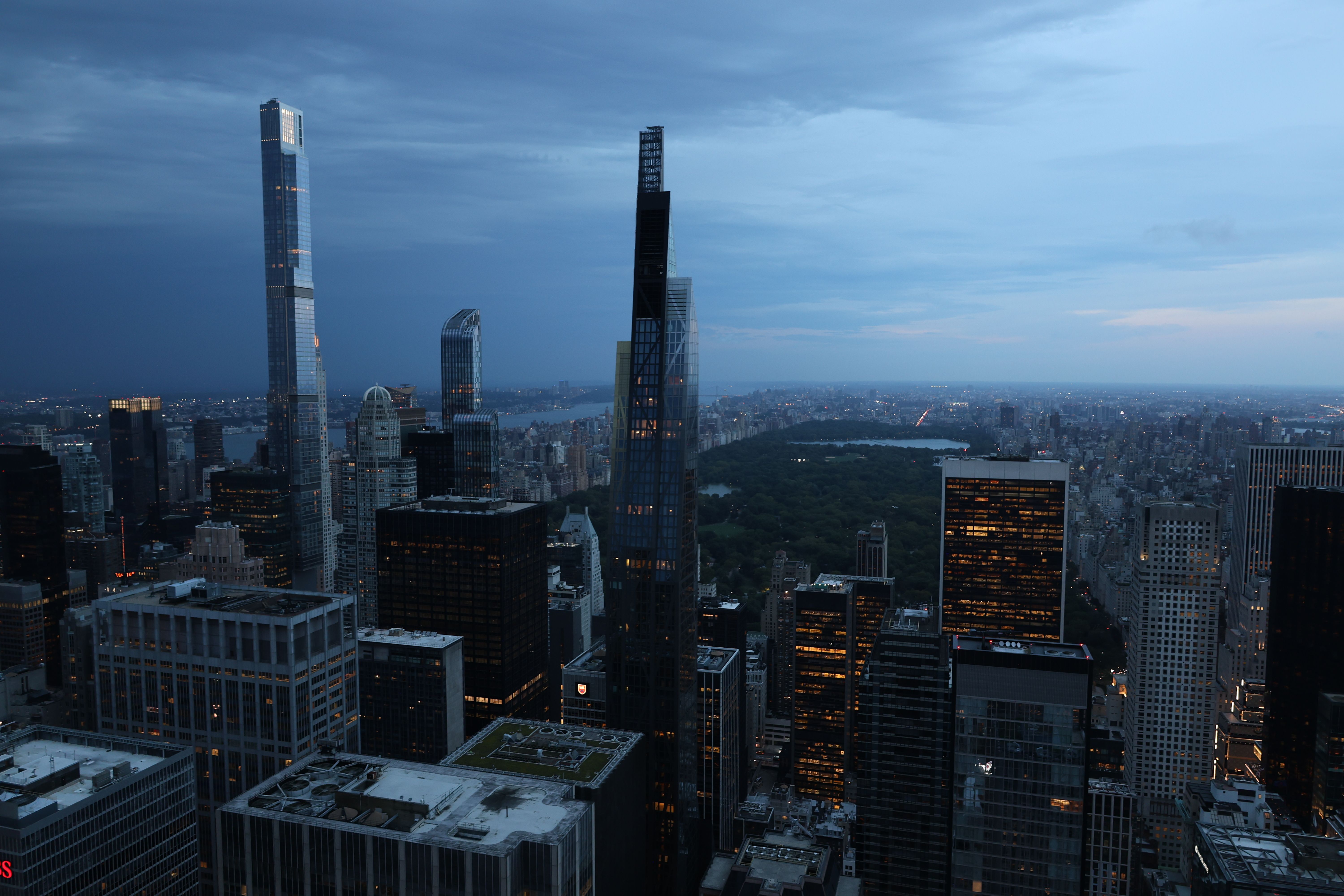 Aerial twilight view of Midtown Manhattan skyscrapers with warm golden light reflecting off glass towers, evoking the financial and insurance industry centered in New York City