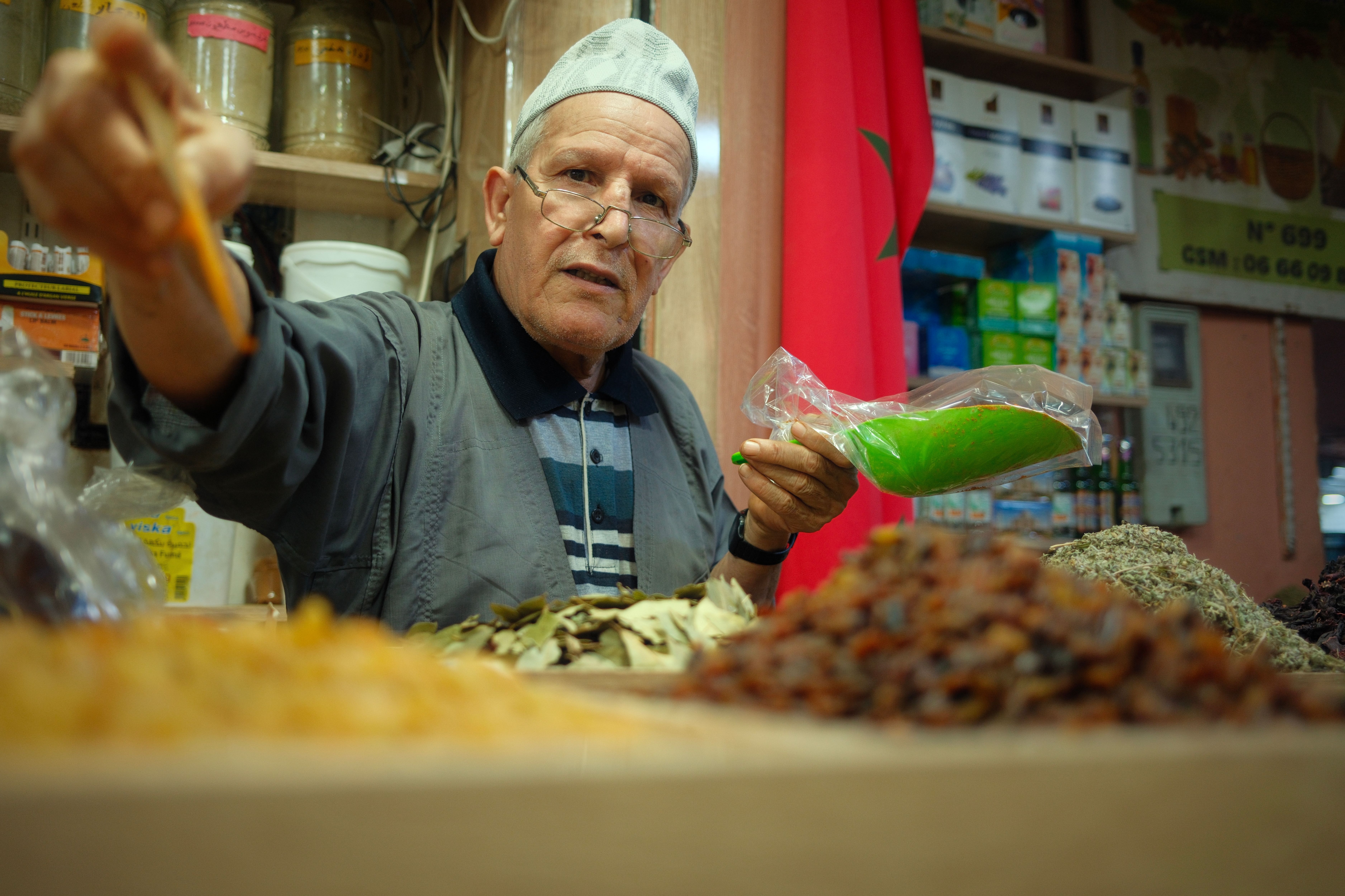 Open-air spice stalls in Marrakech's Rahba Kedima square, with colorful mounds of North African spices and dried herbs arranged by vendors in the medina