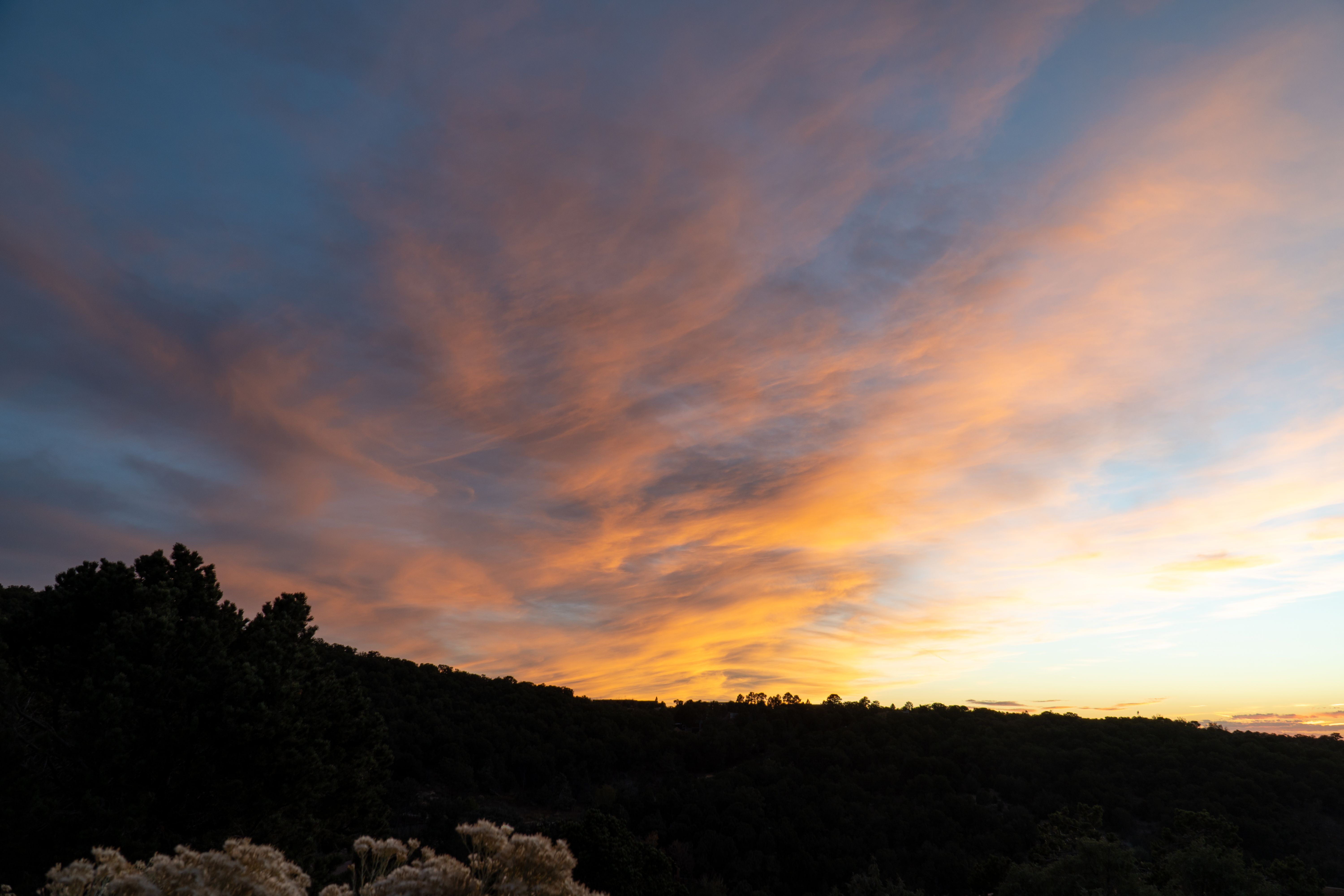 Santa Fe Canyon Road lined with traditional adobe architecture and art galleries under a deep blue New Mexico sky