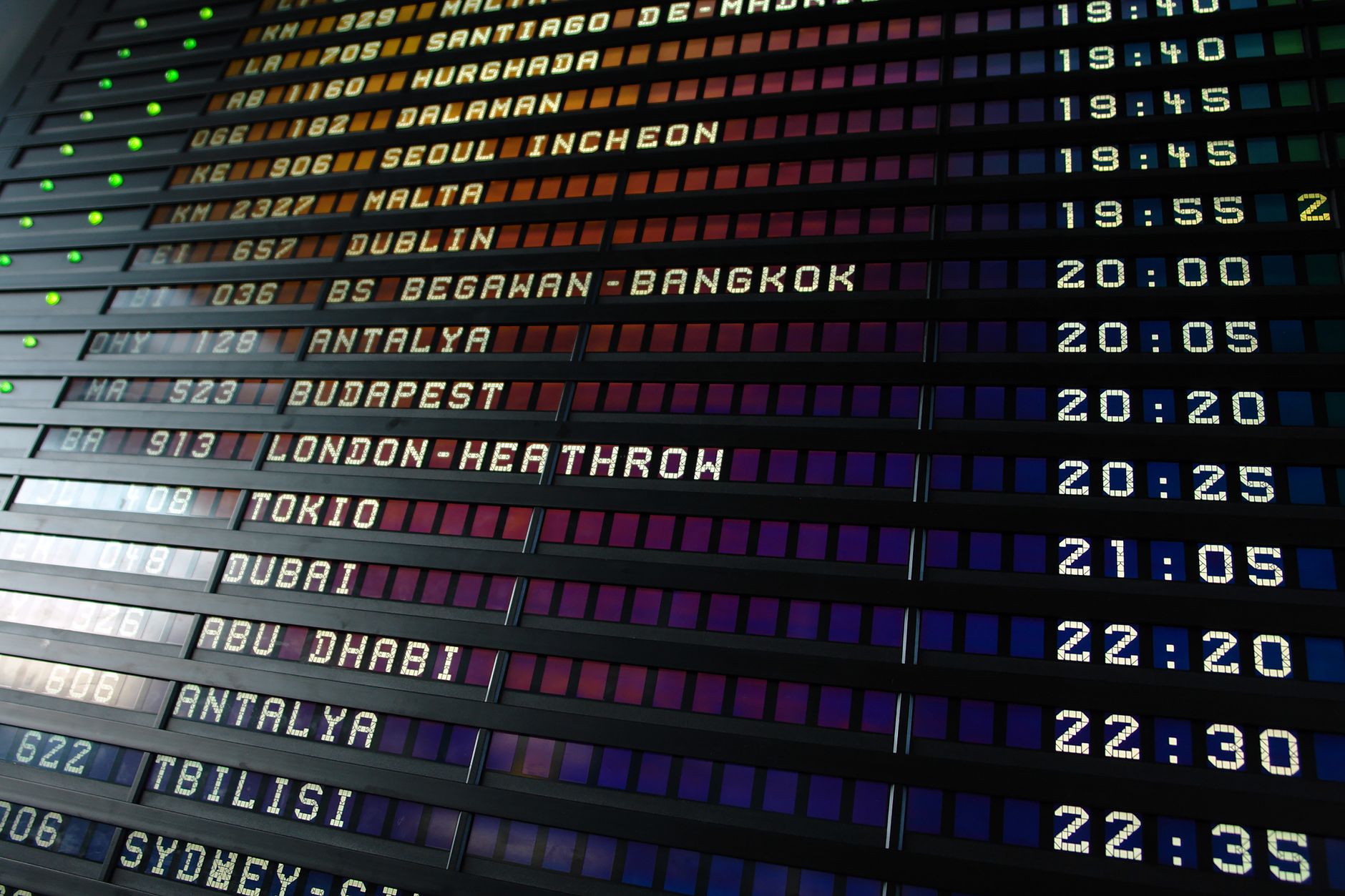Travelers viewing departure board in bright airport terminal