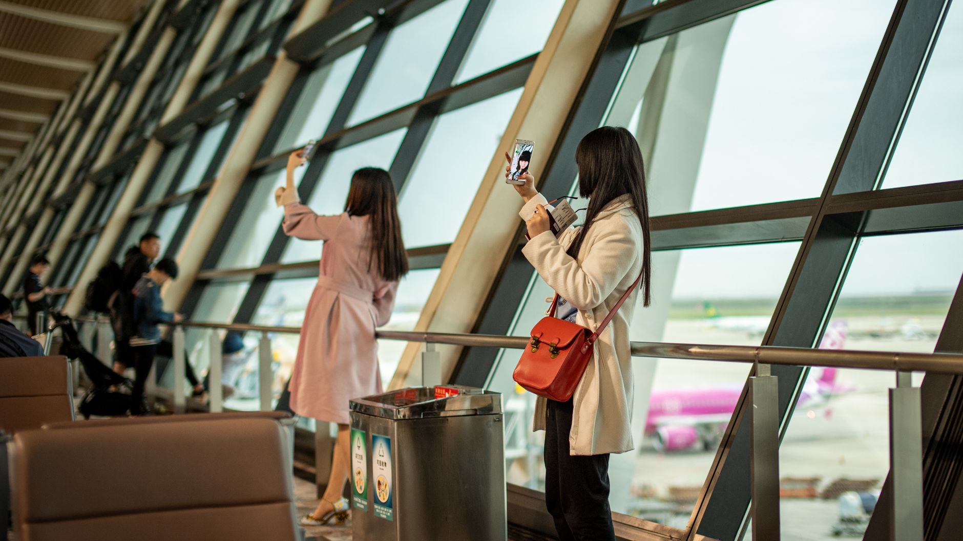 Passenger using smartphone in bright airport terminal