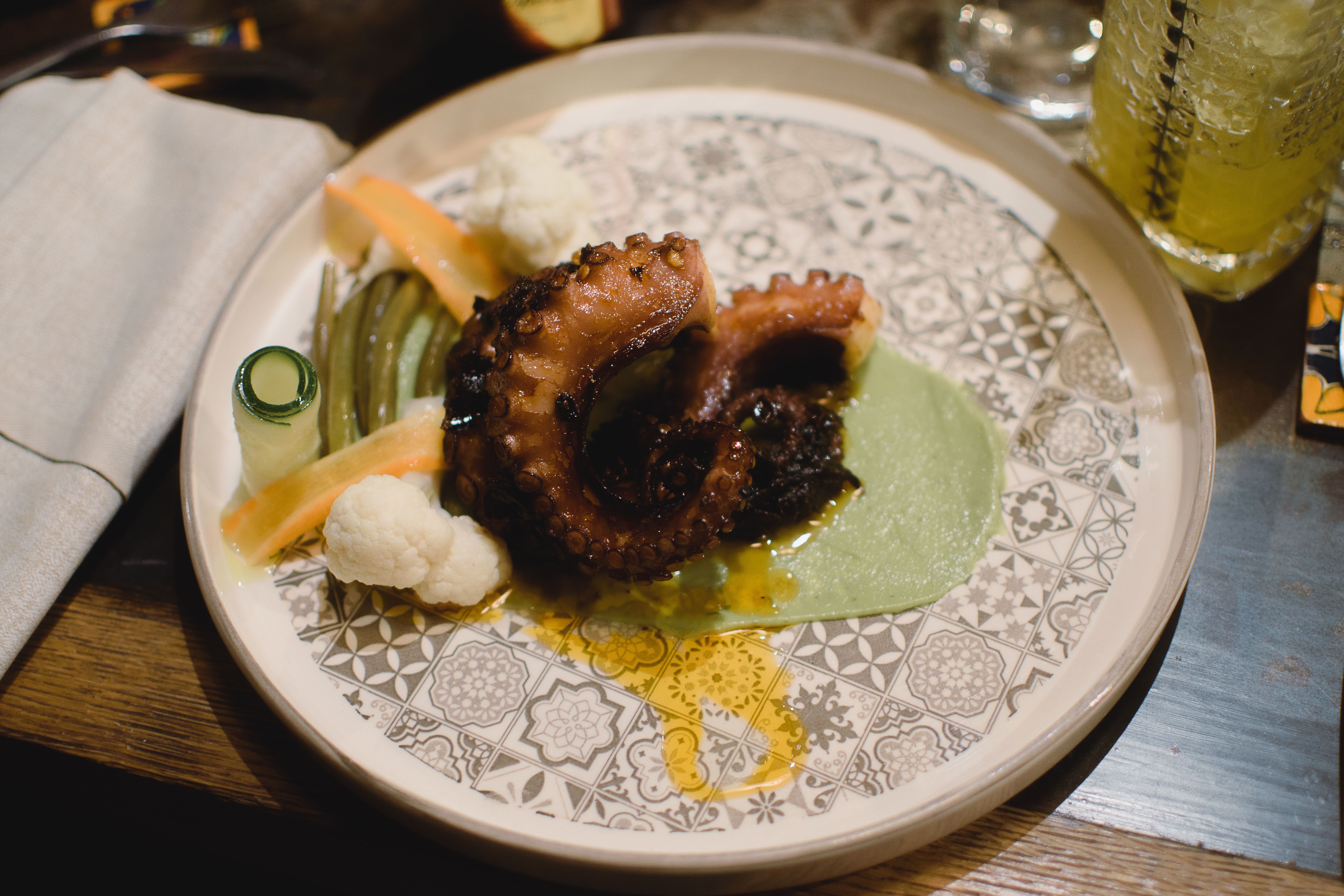 An artfully plated dish from Central restaurant in Lima representing Peru's altitude ecosystems, with carefully arranged indigenous ingredients on a ceramic plate