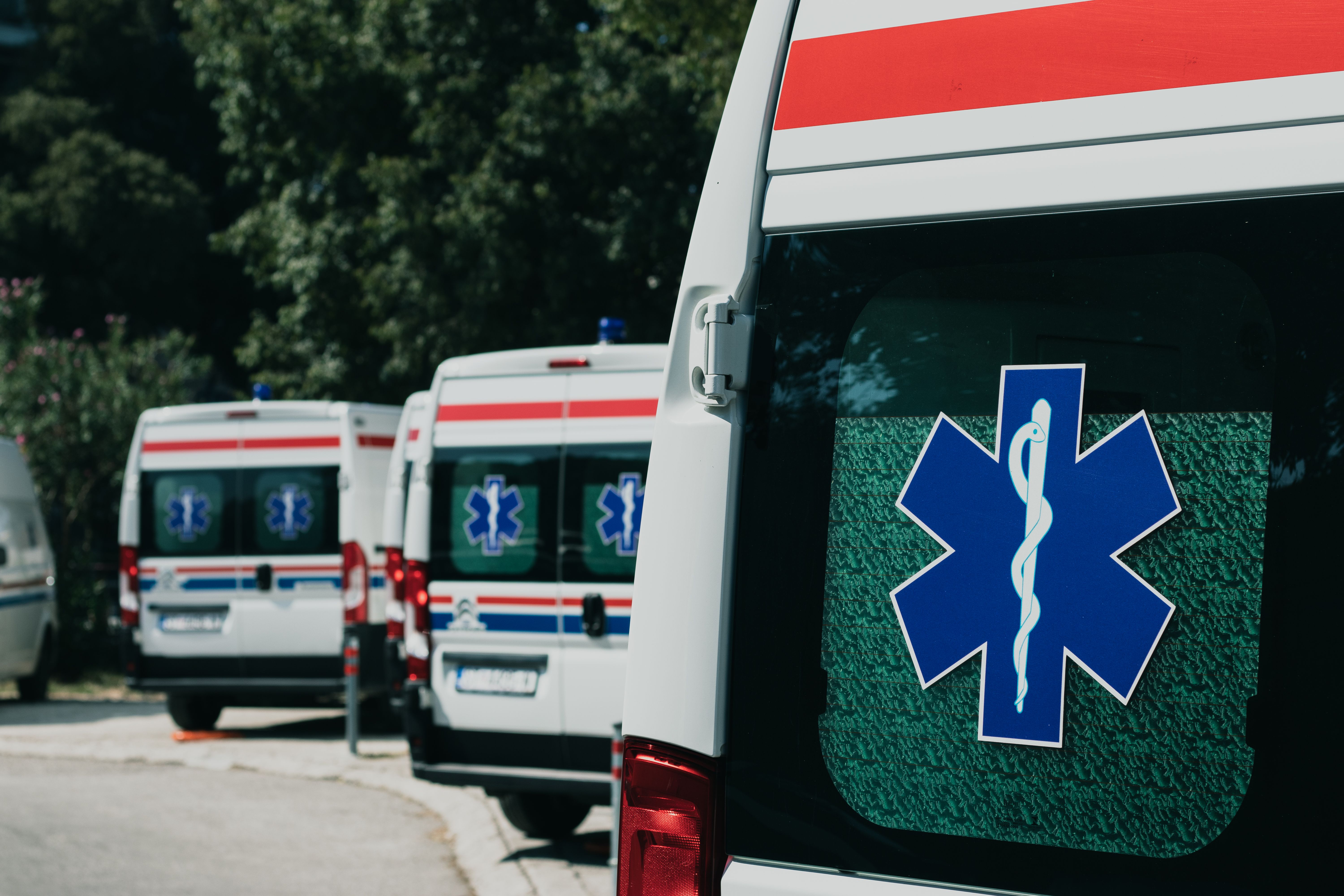 An ambulance on a cobblestone street near a historic Roman building in Rome, Italy