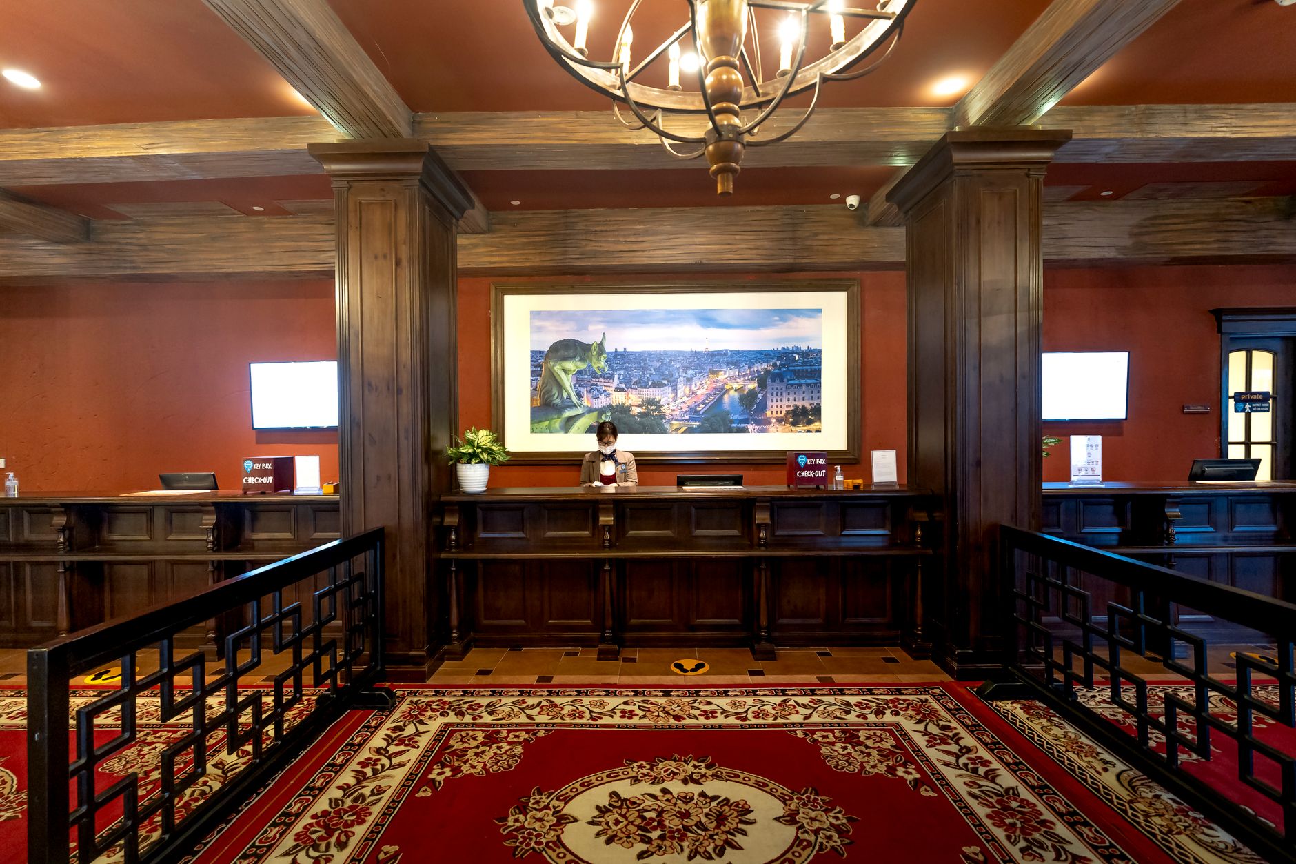 Traveler at hotel front desk with staff member reviewing documents
