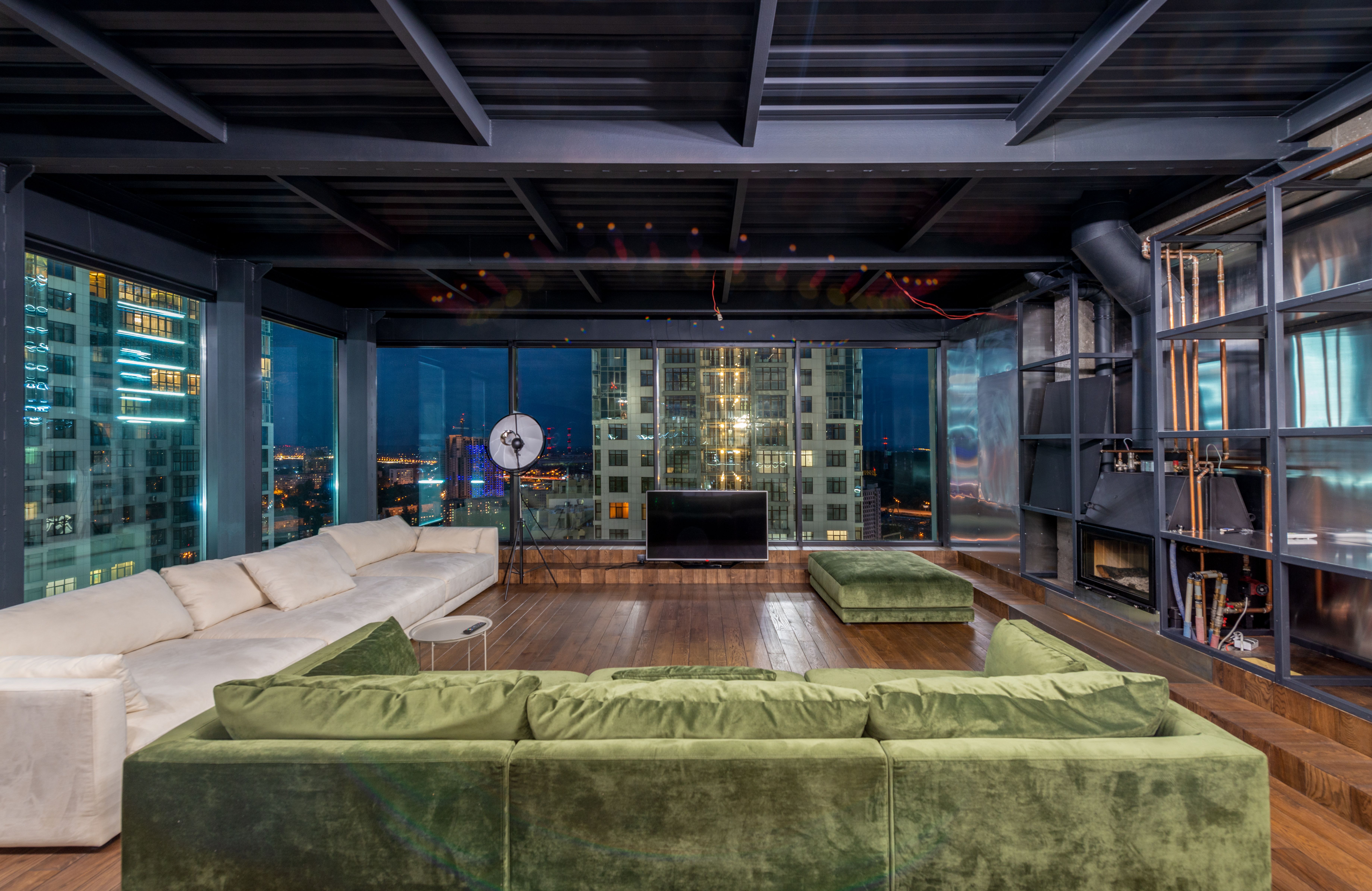 Luxurious Four Seasons hotel suite with panoramic city skyline view through floor-to-ceiling windows, elegant furnishings and champagne service on a marble table