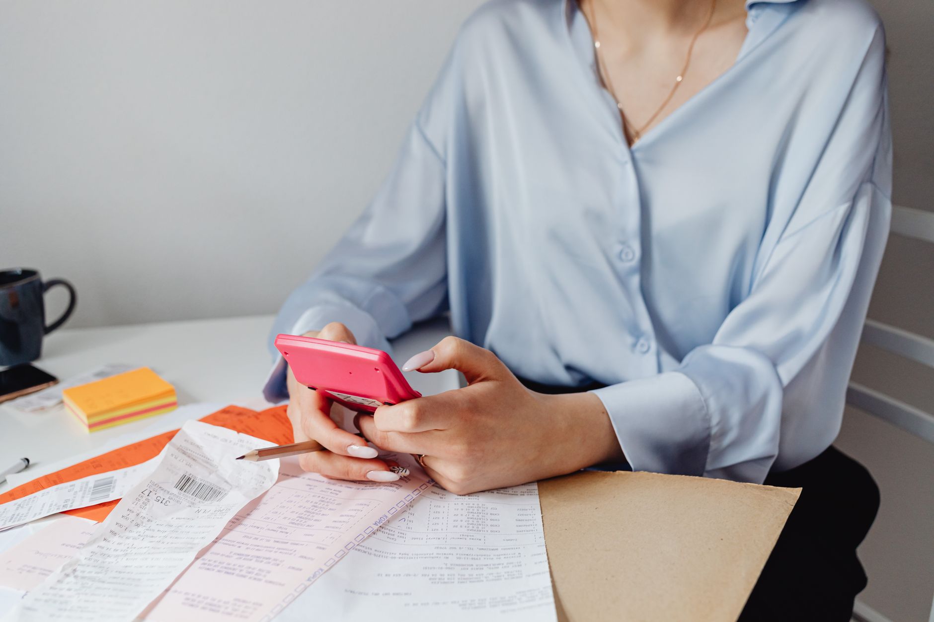 Woman photographing receipts and documenting items on smartphone
