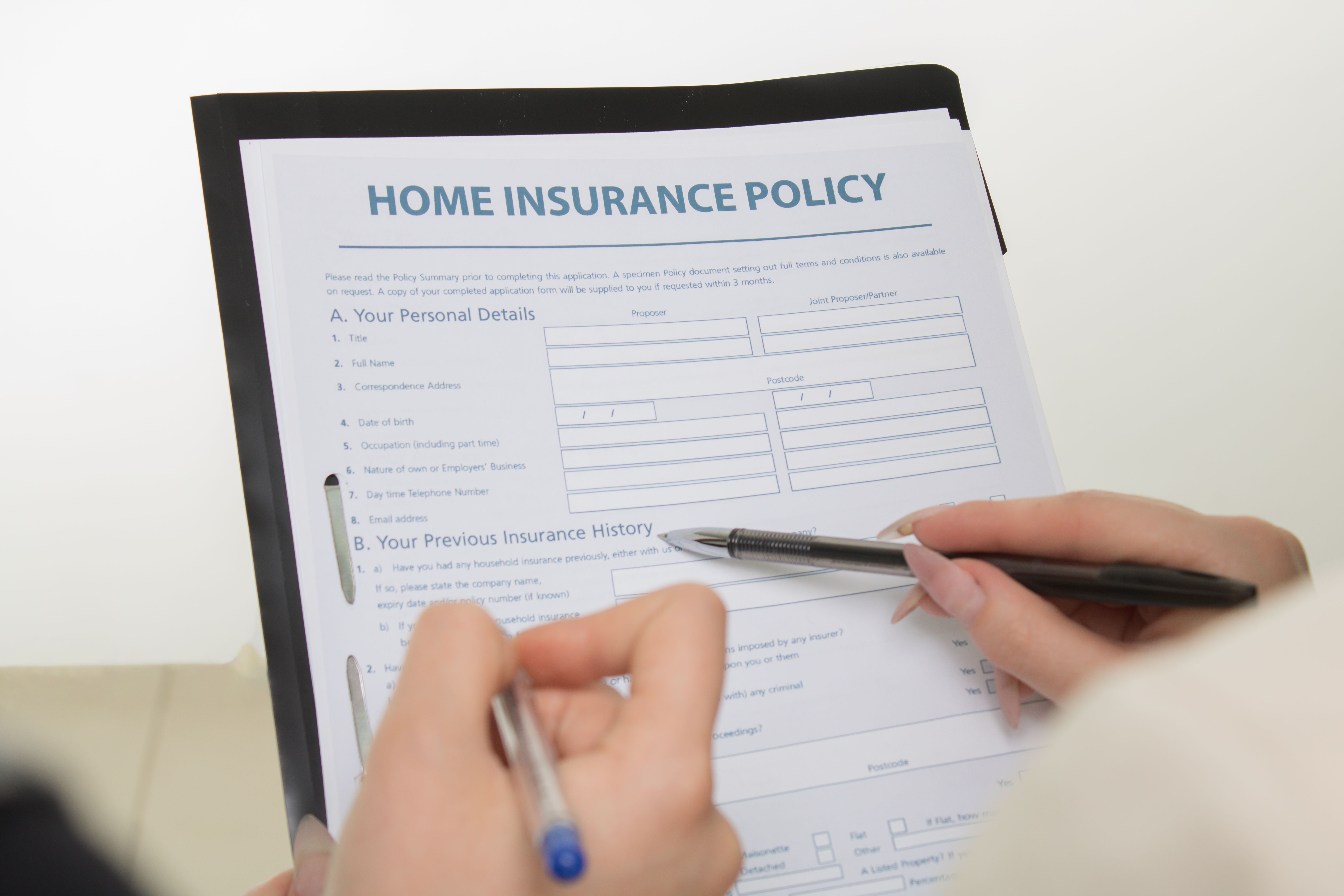 Travel insurance claim form and denial appeal letter with a pen on a desk beside a passport