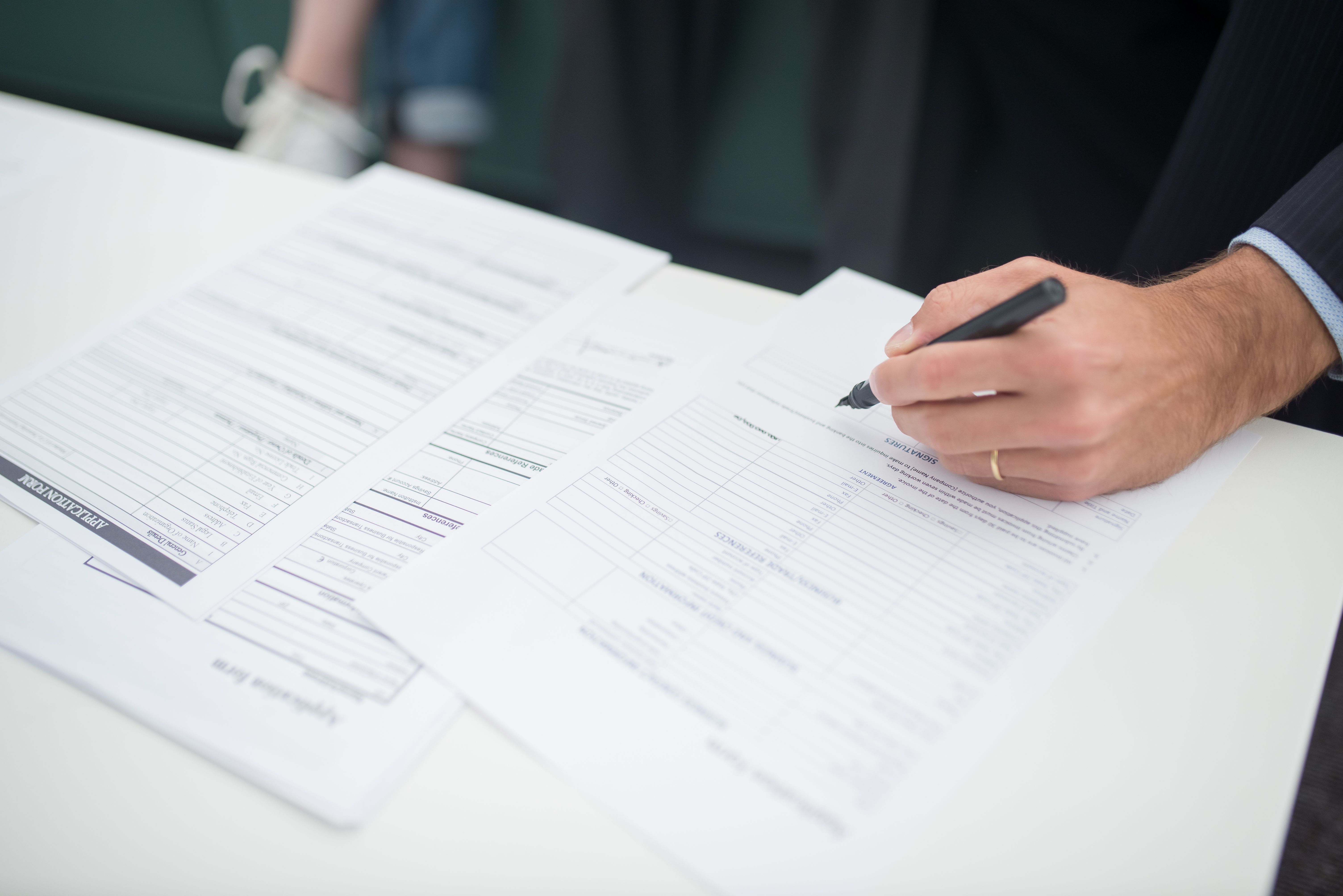 Two travel insurance policy documents placed side by side on a desk with a calculator and a pen for cost comparison