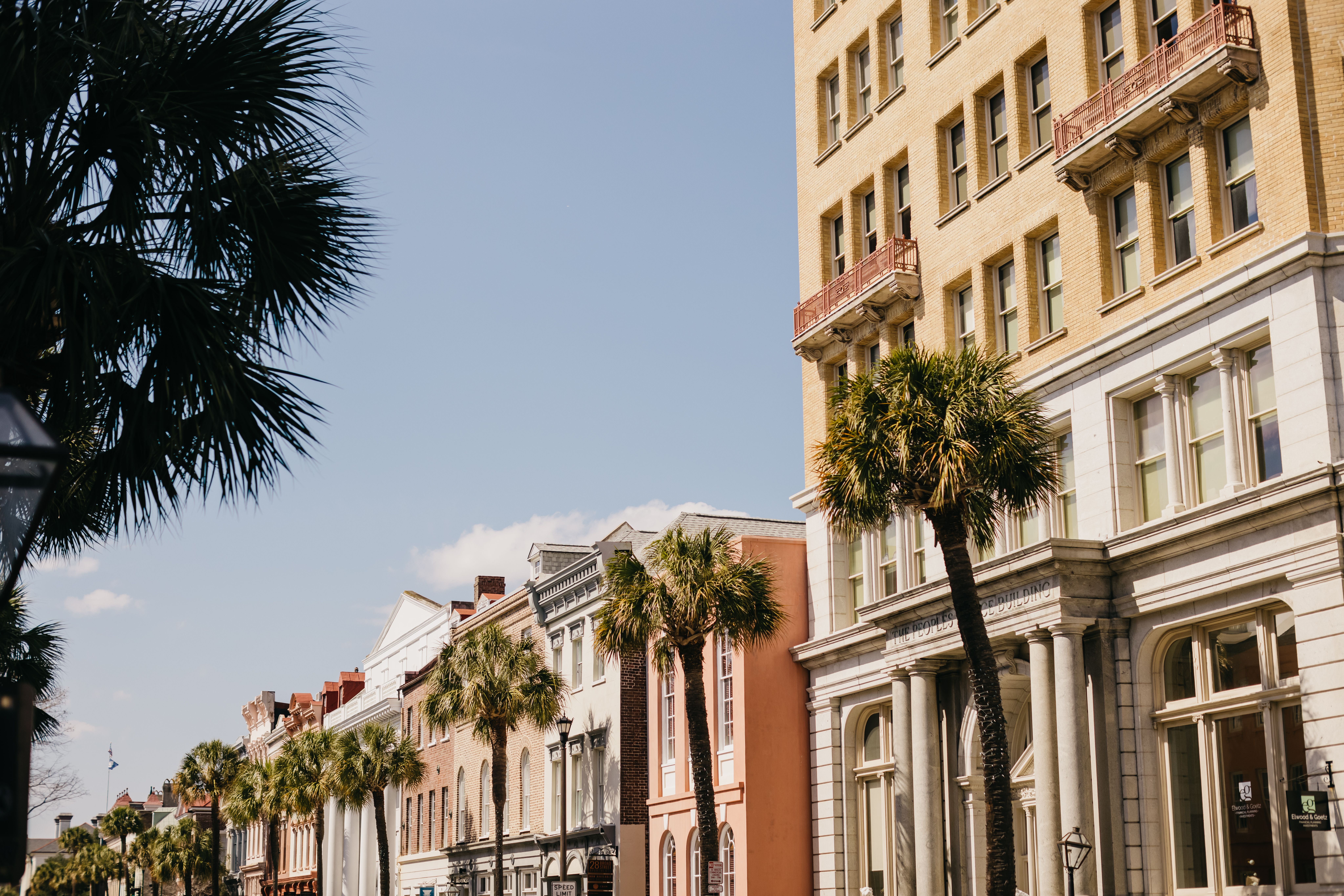 Golden hour light falling across the antebellum facades and wrought-iron balconies of Charleston's King Street hotel district in South Carolina